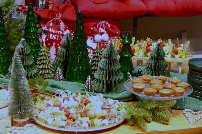 Présentation de la nouvelle collection Noël Maisons du Monde avec une jolie table de Noël Studio Candy pour la presse : sablés décorés, mini gâteaux pain d'épices, brochettes de crudités, grazing cônes, bûche de Noël