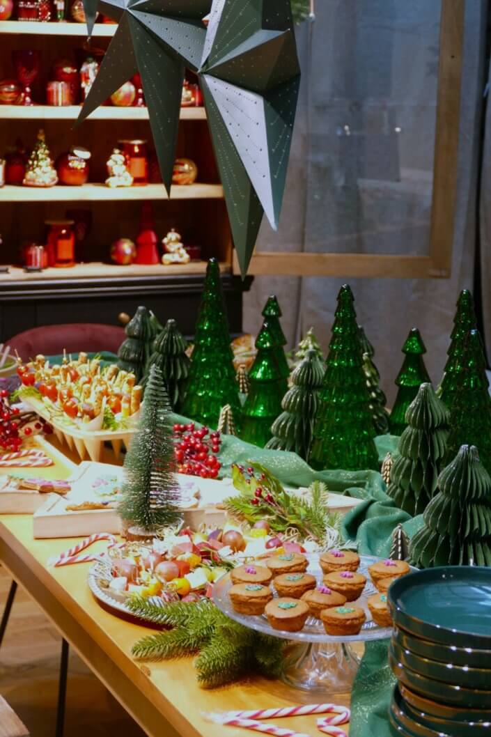 Présentation de la nouvelle collection Noël Maisons du Monde avec une jolie table de Noël Studio Candy pour la presse : sablés décorés, mini gâteaux pain d'épices, brochettes de crudités, grazing cônes, bûche de Noël