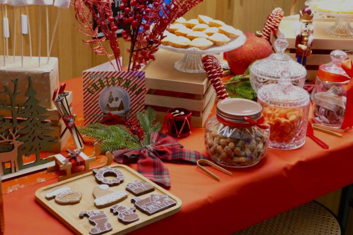 Goûter de Noël traditionnel par Studio Candy chez l'agence médias Dentsu avec sablés décorés de Noël, madeleines, financiers, gaufres au sucre, meringues bonhommes de neige et décoration de Noël sur mesure