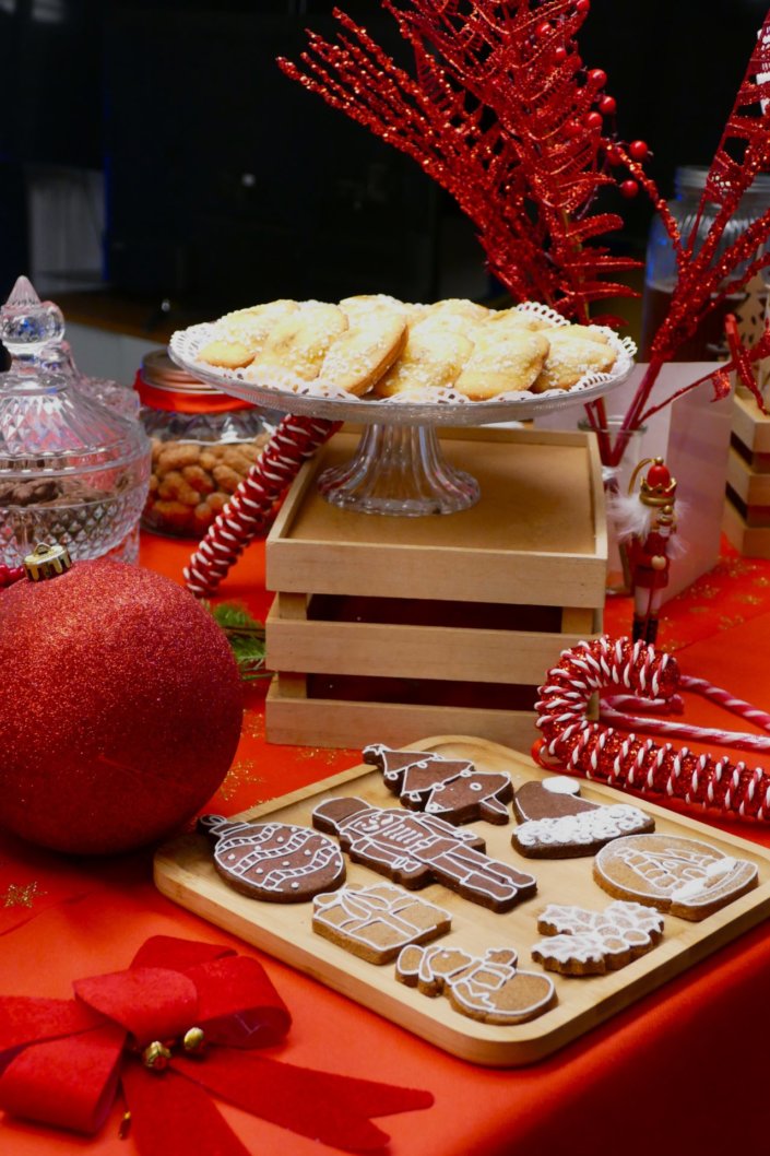 Goûter de Noël traditionnel par Studio Candy chez l'agence médias Dentsu avec sablés décorés de Noël, madeleines, financiers, gaufres au sucre, meringues bonhommes de neige et décoration de Noël sur mesure