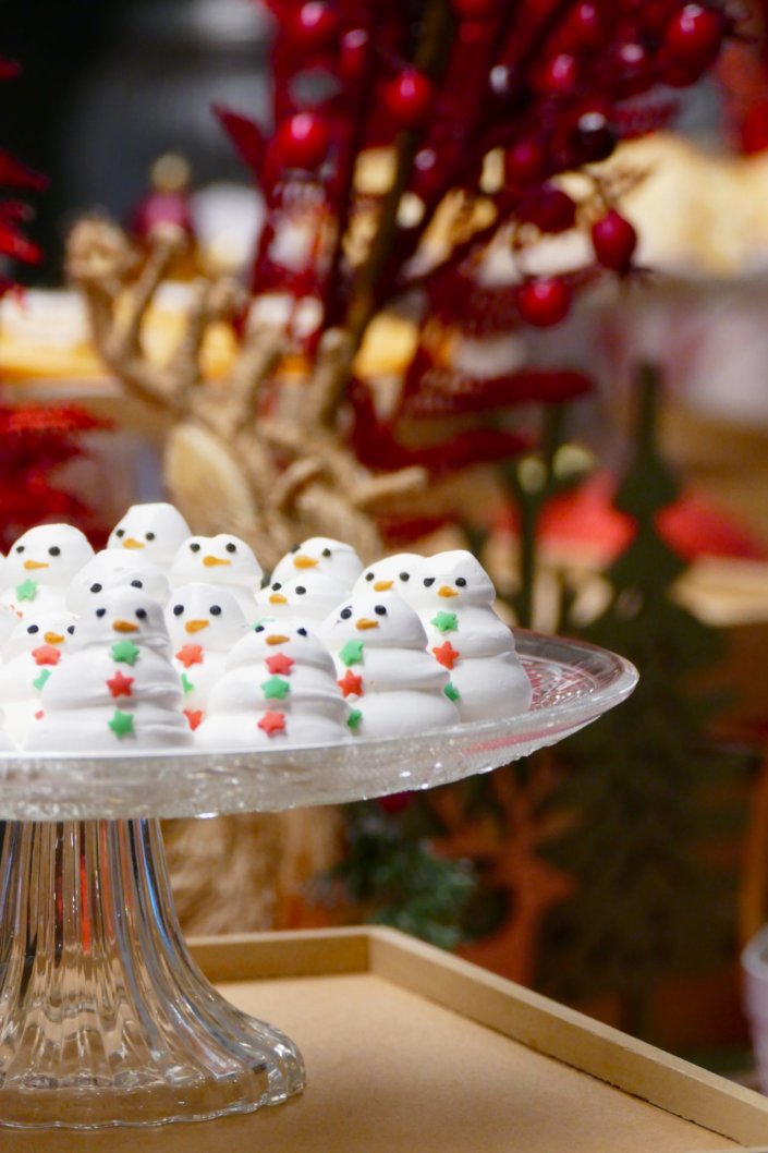 Goûter de Noël traditionnel par Studio Candy chez l'agence médias Dentsu avec sablés décorés de Noël, madeleines, financiers, gaufres au sucre, meringues bonhommes de neige et décoration de Noël sur mesure