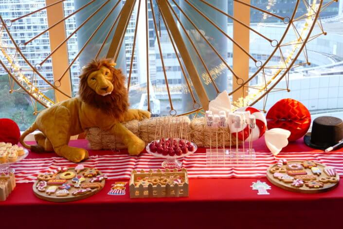 Arbre de Noël chez le groupe Amundi thème Fête Foraine ! Du rouge, des ballons, une grande roue, un lion qui veille sur le goûter des enfants,