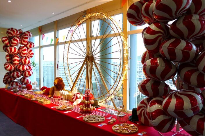 Arbre de Noël chez le groupe Amundi thème Fête Foraine ! Du rouge, des ballons, une grande roue, un lion qui veille sur le goûter des enfants,