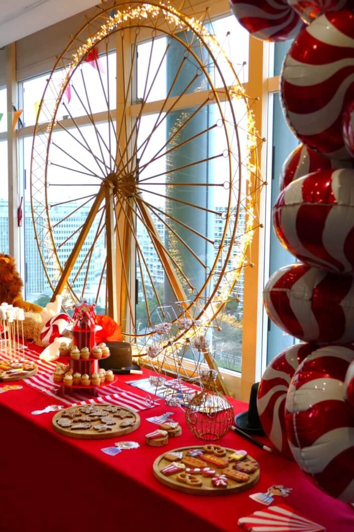 Arbre de Noël chez le groupe Amundi thème Fête Foraine ! Du rouge, des ballons, une grande roue, un lion qui veille sur le goûter des enfants,