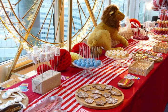 Arbre de Noël chez le groupe Amundi thème Fête Foraine ! Du rouge, des ballons, une grande roue, un lion qui veille sur le goûter des enfants,